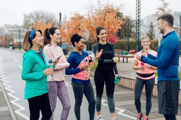 Coach and his female running group having fun after training outdoors EN ARBETSPLATS I RÃRELSE